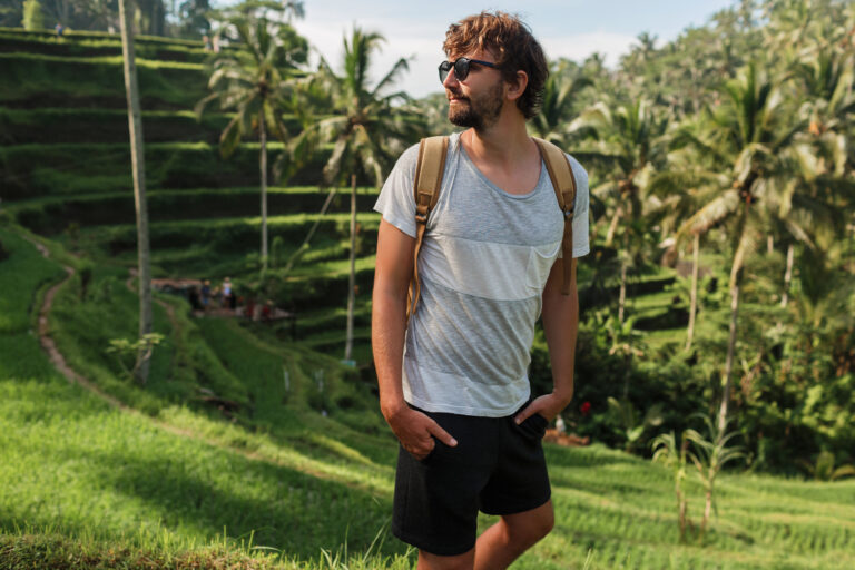 outdoor-portrait-handsome-travel-man-with-back-pack-walking-rise-terrace-bali